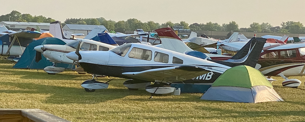 Mockingbird airplane parked near tents at a fly-in